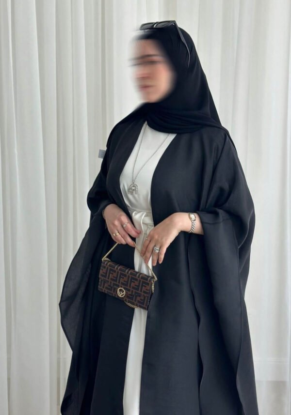 A detailed view of the top area of the Lexus Krepp-Ensemble Elegance Plus abaya, showcasing its balanced beige/white tone, elegant design, and jewelry accents.