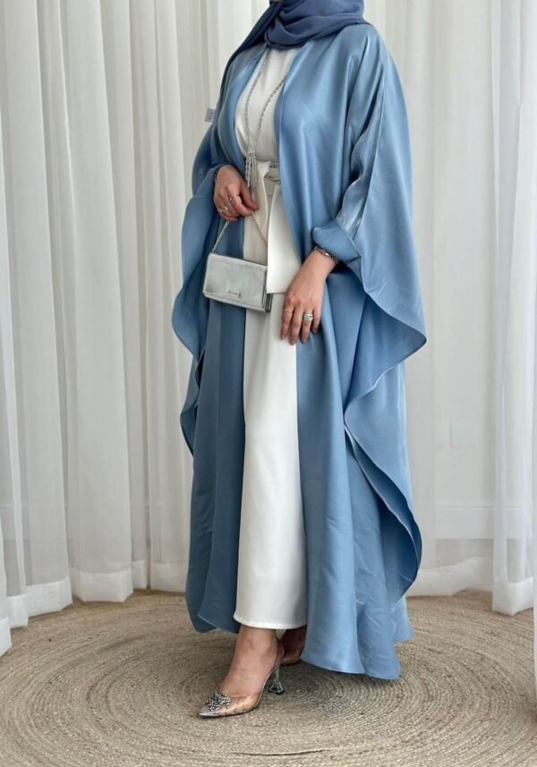 A closer view of the Luxus Lexus-Ensemble Royal abaya, showcasing the light beige and white interior, light blue exterior, and elegant shoes, emphasizing the lower part of the outfit.