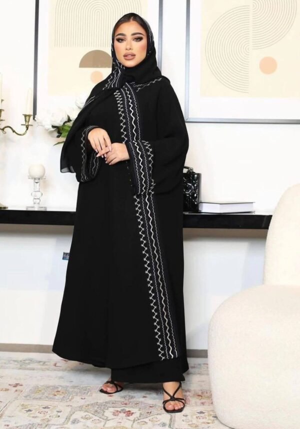 A young lady wearing the Premium Krepp-Abaya Tradition, a black abaya with elegant border patterns, showcasing timeless style and sophistication.