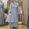 Eine Frau trägt die königliche Chiffon-Abaya in Himmelblau mit glitzernden Akzenten, ideal für elegante Anlässe.