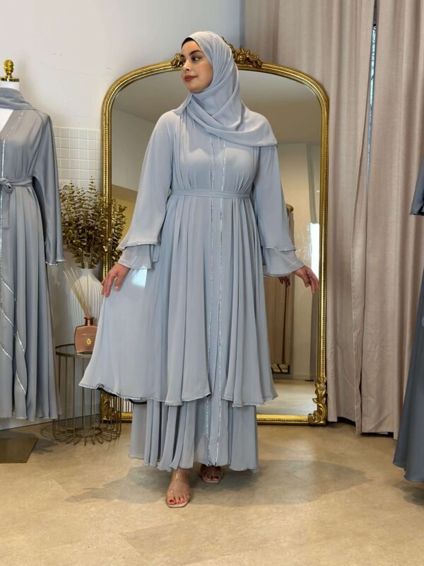 Eine Frau trägt die königliche Chiffon-Abaya in Himmelblau mit glitzernden Akzenten, ideal für elegante Anlässe.