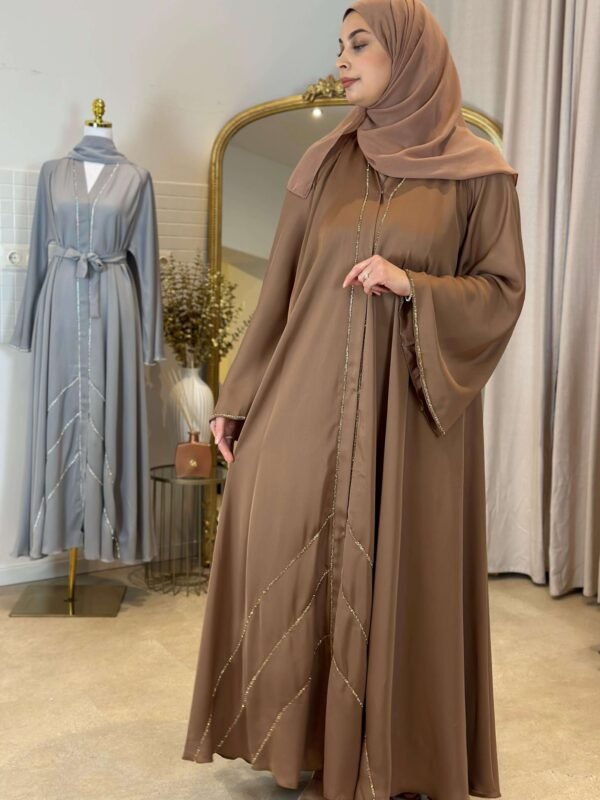 Seitlicher Blick auf die braune Abaya mit schlichten und eleganten Goldverzierungen.