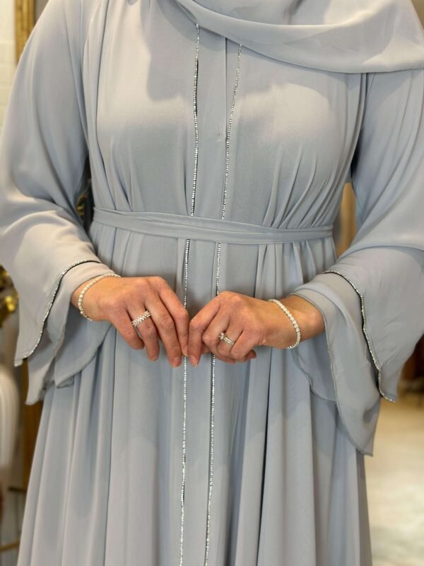 Nahaufnahme der glitzernden Akzente der königlichen Chiffon-Abaya in Himmelblau, die die feine Verarbeitung zeigt.