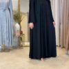 Vorderansicht der Luxus Krepp-Internet-Abaya in Schwarz, elegant kombiniert mit minimalistischem Stil.