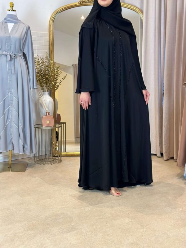 Vorderansicht der Luxus Krepp-Internet-Abaya in Schwarz, elegant kombiniert mit minimalistischem Stil.
