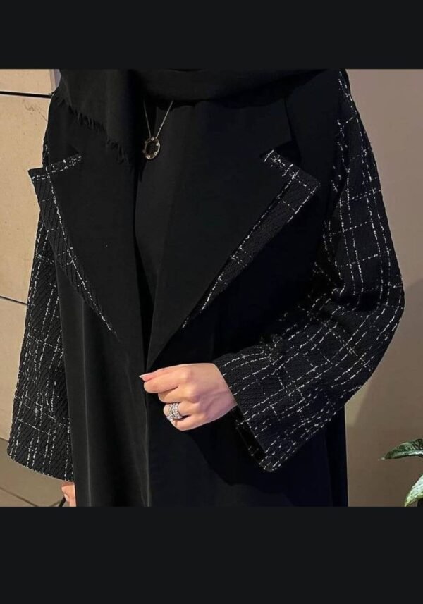 A lady wearing the elegant Luxus Chamois-Abaya 'Charme,' featuring a refined and sophisticated design in classic black.