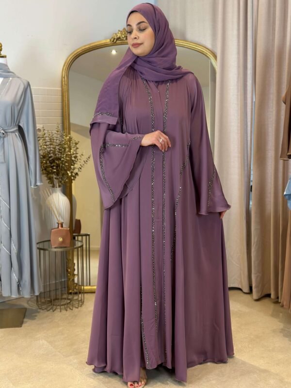 Eine Frau präsentiert die Luxus Krepp-Internet-Abaya in Lavendel aus der Seitenansicht, mit funkelnden Akzenten und fließendem Design.