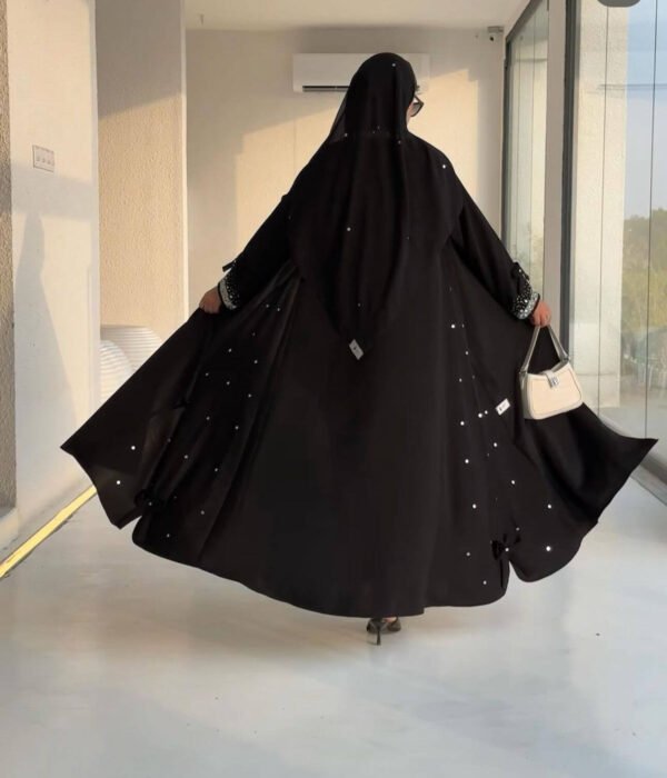 Rückansicht der Royal Krepp-Abaya mit fließendem Stoff und eleganten Details, kombiniert mit einer Tasche.