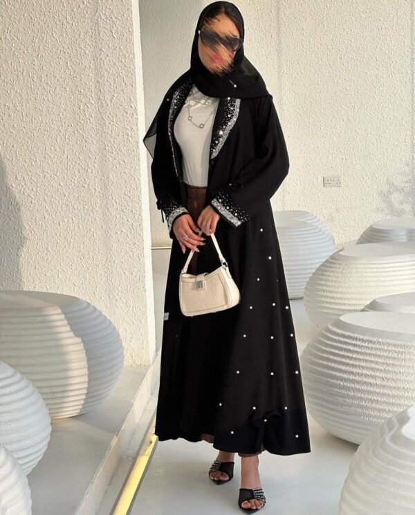 Rückansicht der Royal Krepp-Abaya mit fließendem Stoff und eleganten Details, kombiniert mit einer Tasche.