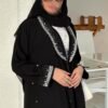 Eine Frau in der Royal Krepp-Abaya zeigt die Seitenansicht, mit eleganten Details an Ärmeln und Saum, kombiniert mit Absätzen.