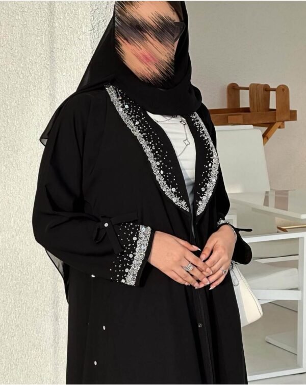 Eine Frau in der Royal Krepp-Abaya zeigt die Seitenansicht, mit eleganten Details an Ärmeln und Saum, kombiniert mit Absätzen.
