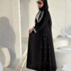 Eine Frau in der Royal Krepp-Abaya zeigt die Seitenansicht, mit eleganten Details an Ärmeln und Saum, kombiniert mit Absätzen.